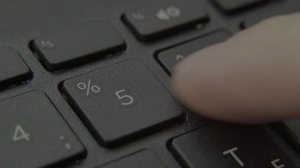 The Finger Presses a Button with a Number on the Keyboard