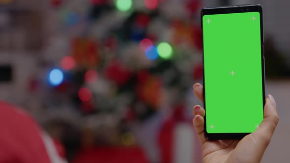 Close Up of Hand Vertically Holding Smartphone with Green Screen