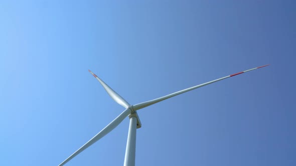 Wind turbine generating electricity on blue sky, sustainable development, renewable energy