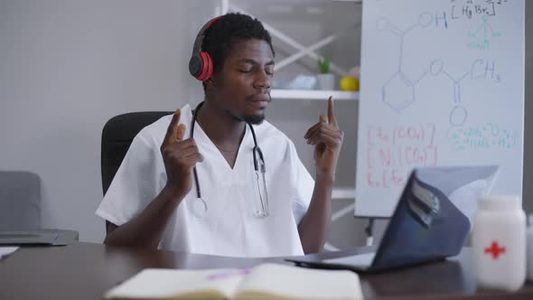 Portrait of African American Man Listening to Music in Headphones with Closed Eyes