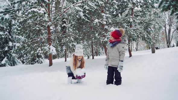 An Amusing Girl with a Large Lump of Snow in Her Hands 