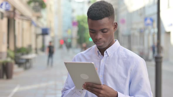 African Man Celebrating on Tablet While Standing Outdoor