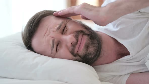 Close Up of Sleepless Beard Young Man Having Headache in Bed 