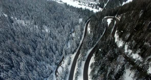 AERIAL: Road in Forest with snow in Dolomites