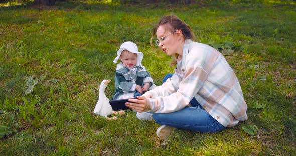 Young Mother with a Child Watching Interesting Educational Videos for Children Through an Online