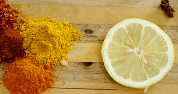 Various spices with lemon slice and knife on chopping board 4k