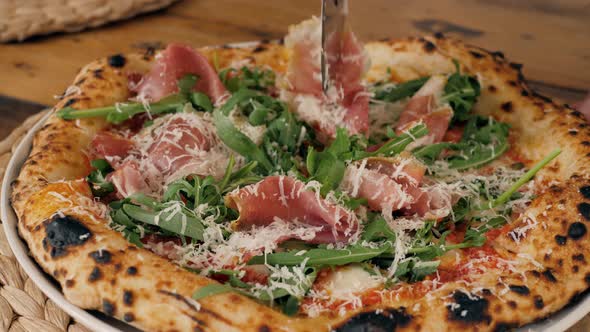 The Close-up Chef Grating the Cheese on the Tasty Pizza Close Up Parmesan Prosciutto.