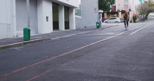 Caucasian male smiling and riding his bike in a street