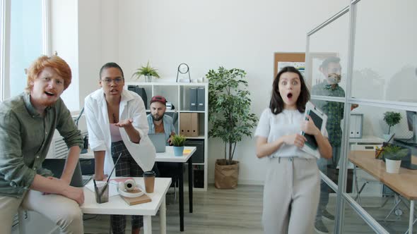 Emotional Office Workers Pointing at Camera and Laughing Making Funny Faces Indoors in Workplace