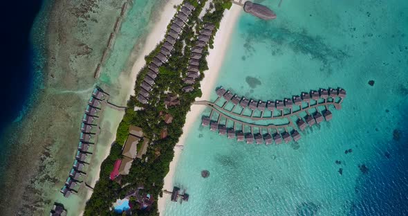 Daytime aerial island view of a white sand paradise beach and blue sea background in colorful 4K