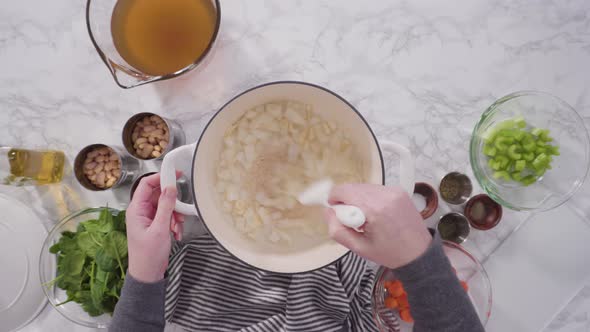 Cooking vegetarian white bean soup in cast iron dutch oven