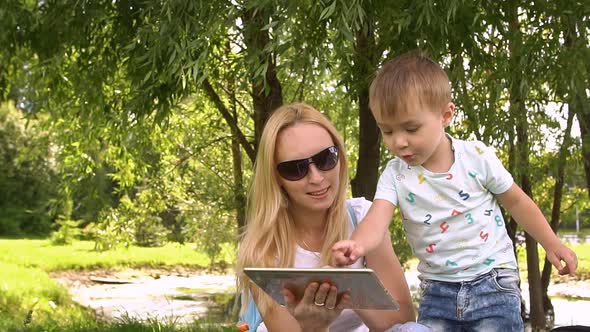 Happy Mother and Son Playing on Tablet Computer. Slow Motion.