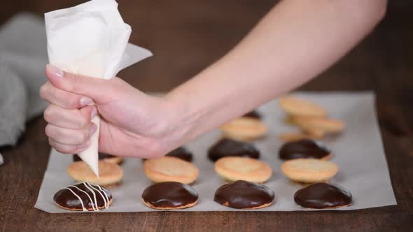 Female Chef Decorating Cookies with Melted Chocolate