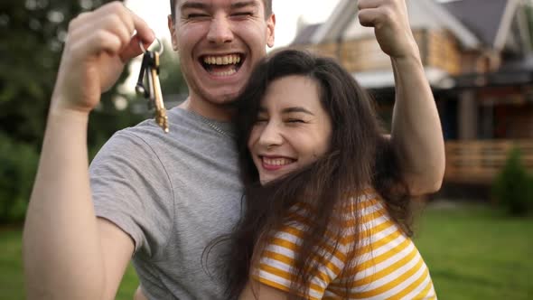 Very Happy Man and Asian Woman is Owners Shake Key and Hug Each Other in Front of Their Newly Bought