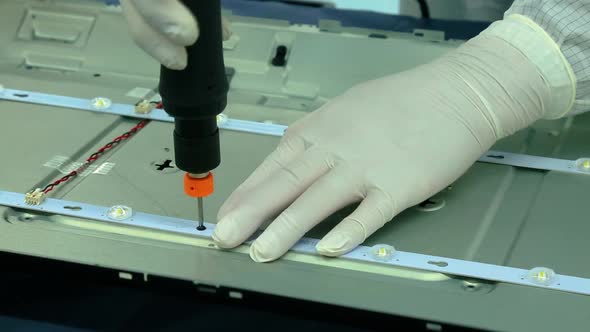 worker is assembling the back of a TV