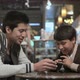 Two brothers with smartphone in cafe - VideoHive Item for Sale