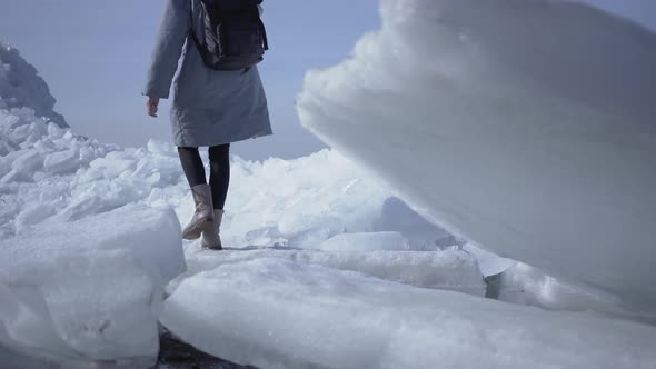 Young Woman in Warm Jacket Walking on the Glacier