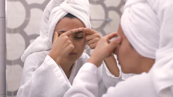 Woman Squeezing Pimples at the Bathroom