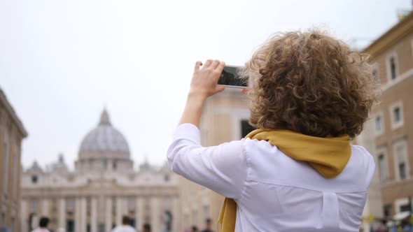 Young Woman Taking Picture Of Tourist Attraction With Smartphone Traveling In Europe