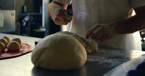 Chef spreading flour on dough in kitchen 4k
