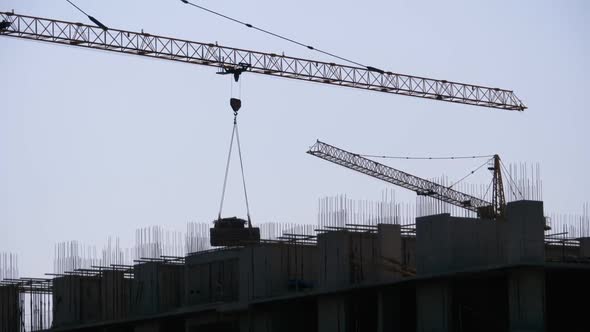 Building Construction. Tower Crane on a Construction Site Lifting Wall Panel