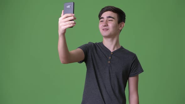 Young Handsome Iranian Teenage Boy Against Green Background