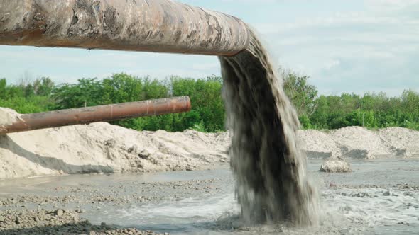 Wastewater from Large Rust Pipe Merge into Environment on background Forest