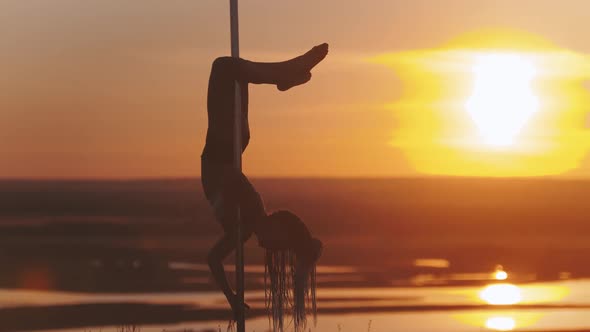 Pole Dance on Sunset - Young Woman Holding By the Dancing Pole Upside Down