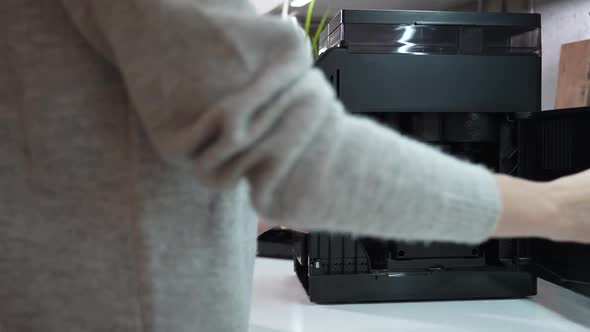 Woman Opens a Coffee Machine and Removes a Brewing Unit