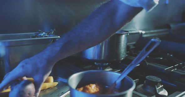 Hands of professional chef putting vegetables into boiling water