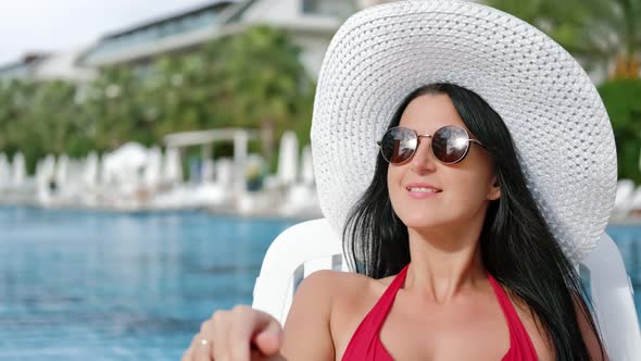 Closeup Face of Adorable Fashion Female Relaxing in Swimsuit on Deck Chair Having Positive Emotion