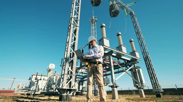 Energy Engineer Maintaining a Power Plant Using Laptop