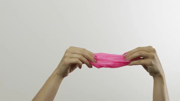 Woman Hands Playing Oddly Satisfying Pink Slime on White Background. Antistress