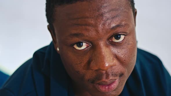 Happy African Guy Sitting on Bed Smiling at Camera Closeup