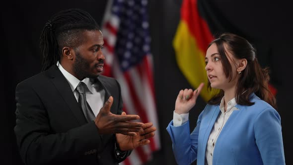 African American and Caucasian Diplomats Arguing at Press Conference with USA and German Flags at