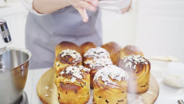 a Female Cook Sprinkles with Powdered Sugar and Almonds a Kraffin Easter Cake