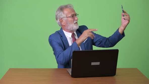 Handsome Senior Bearded Businessman Against Green Background