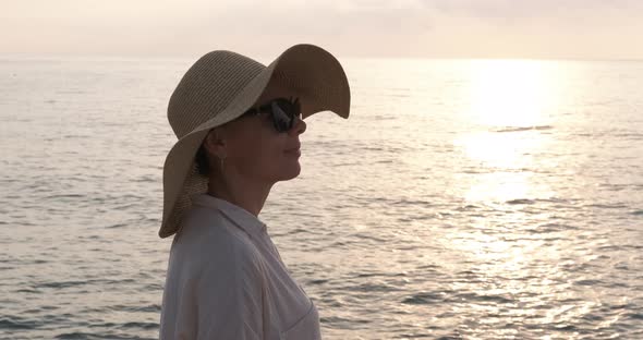 Woman in sunhat on beach.