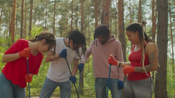 Diverse Eco Activists Picking Up Trash in Forest