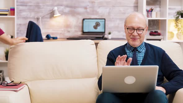 Happy Senior Middle Aged Couple Sitting on Sofa Having a Video Call