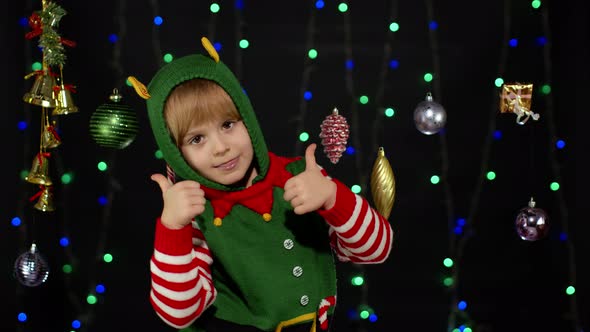Teen Kid Girl Christmas Elf Santa Claus Helper Costume Showing Thumbs Up Black Background