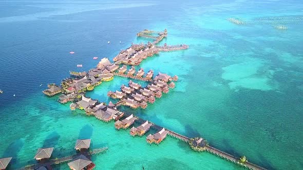 Aerial flight over crystal clear water and resort in Malaysia, medium distance shot moving forward i