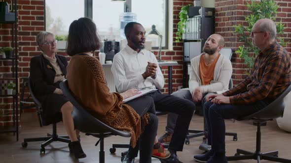 African American Man Sharing Addiction Story with Group of People at Aa Therapy Meeting