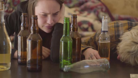 Bad Looking Teens Lying on the Table Near Empty Alcohol Bottles