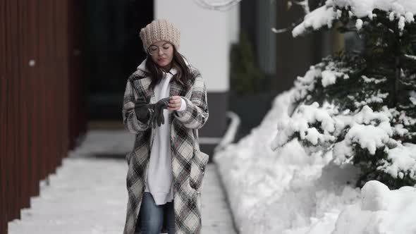 Walk in Winter City at Daytime Young Woman Is Wearing Gloves on Hands Feeling Cold