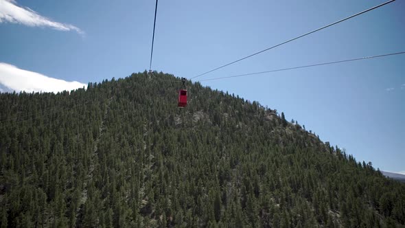 Red gondola passing by gondola going up mountain