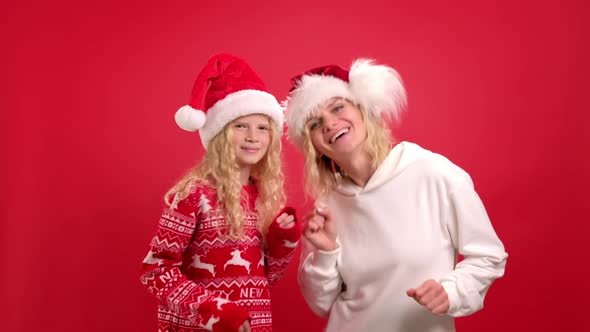 Christmas Holidays Portrait Happy Family of Two In Santa Hats Mother and Daughter Dancing and