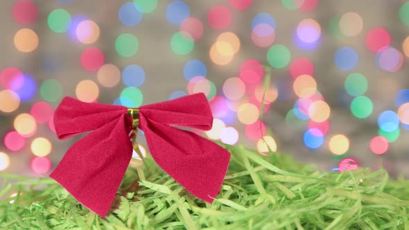 Red Christmas Bow on Green Tinsel New Year Background