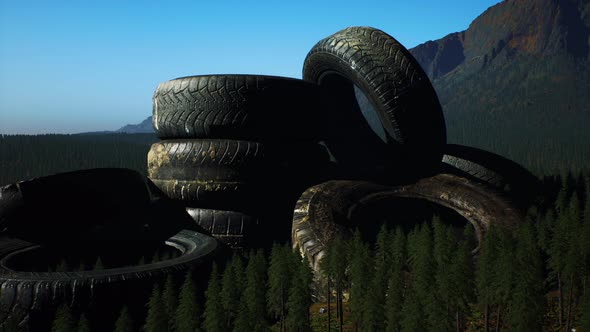 Concept of Environmental Pollution with Big Old Tires in Mountain Forest alt
