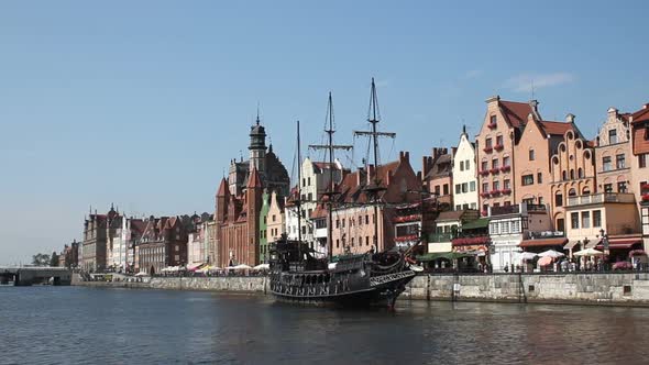 Waterfront with Historical Terraced Houses, Stylized Old Ship Sailing on River